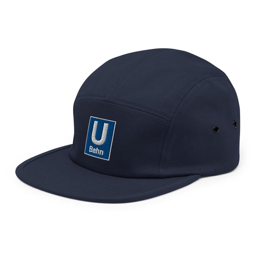 Donkerblauwe 5-panel pet met een geborduurd Berlijn Metro Logo, ontwerp door De Zwarte Markt en verkrijgbaar bij cadeauwinkel 'A Given Horse'. Schuin.