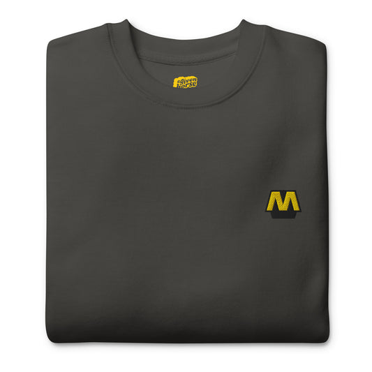 Donkergrijze trui met het Metro logo geborduurd op de borst, ontwerp door De Zwarte Markt en verkrijgbaar bij cadeauwinkel 'A Given Horse'. Gevouwen.